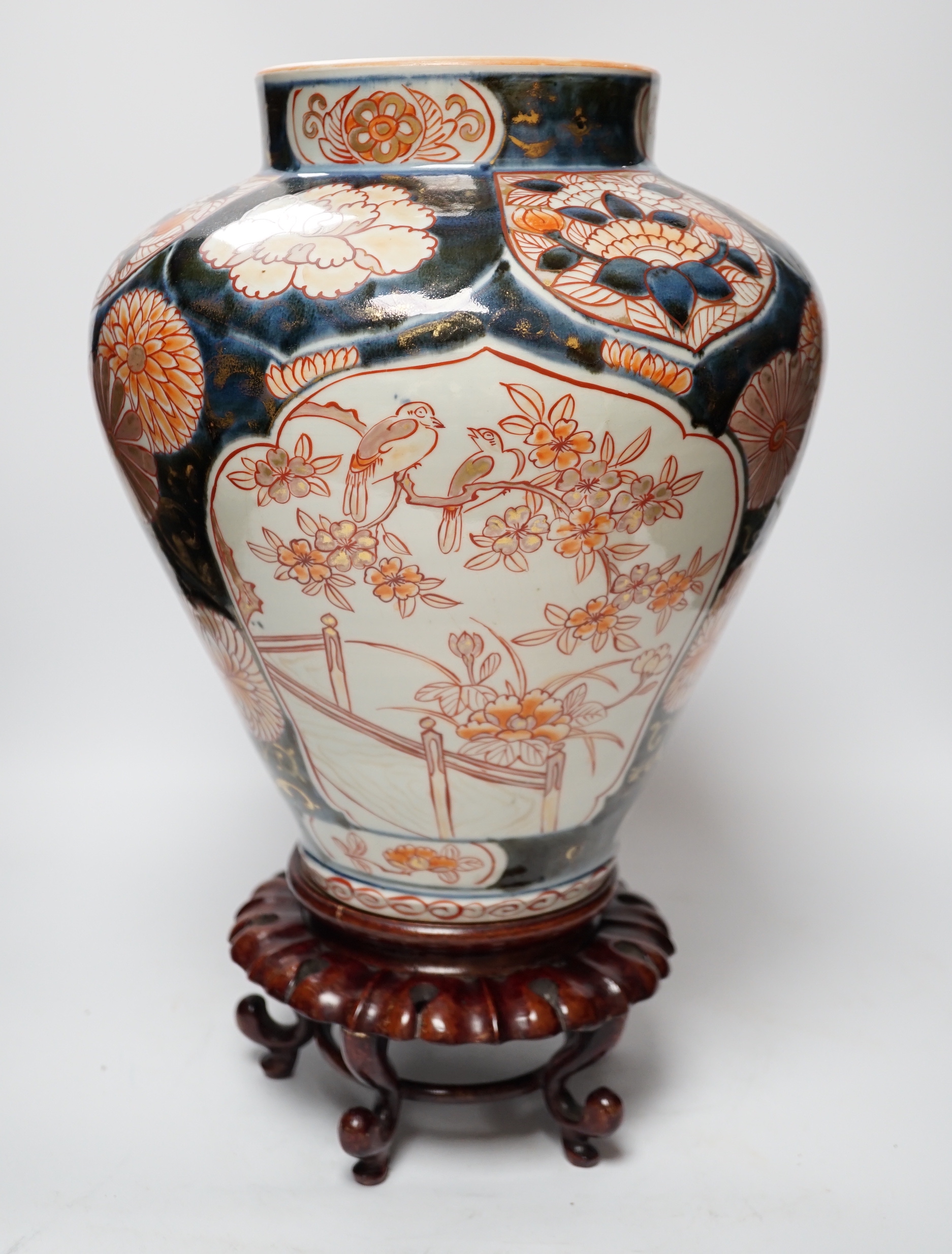 A Japanese Arita Imari pattern vase, c.1690, restored, with an unmatched wooden stand, vase 31cm high